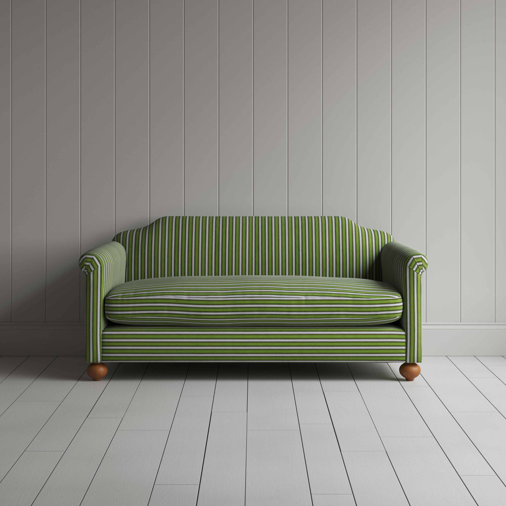 A green and white striped couch against a wall.
