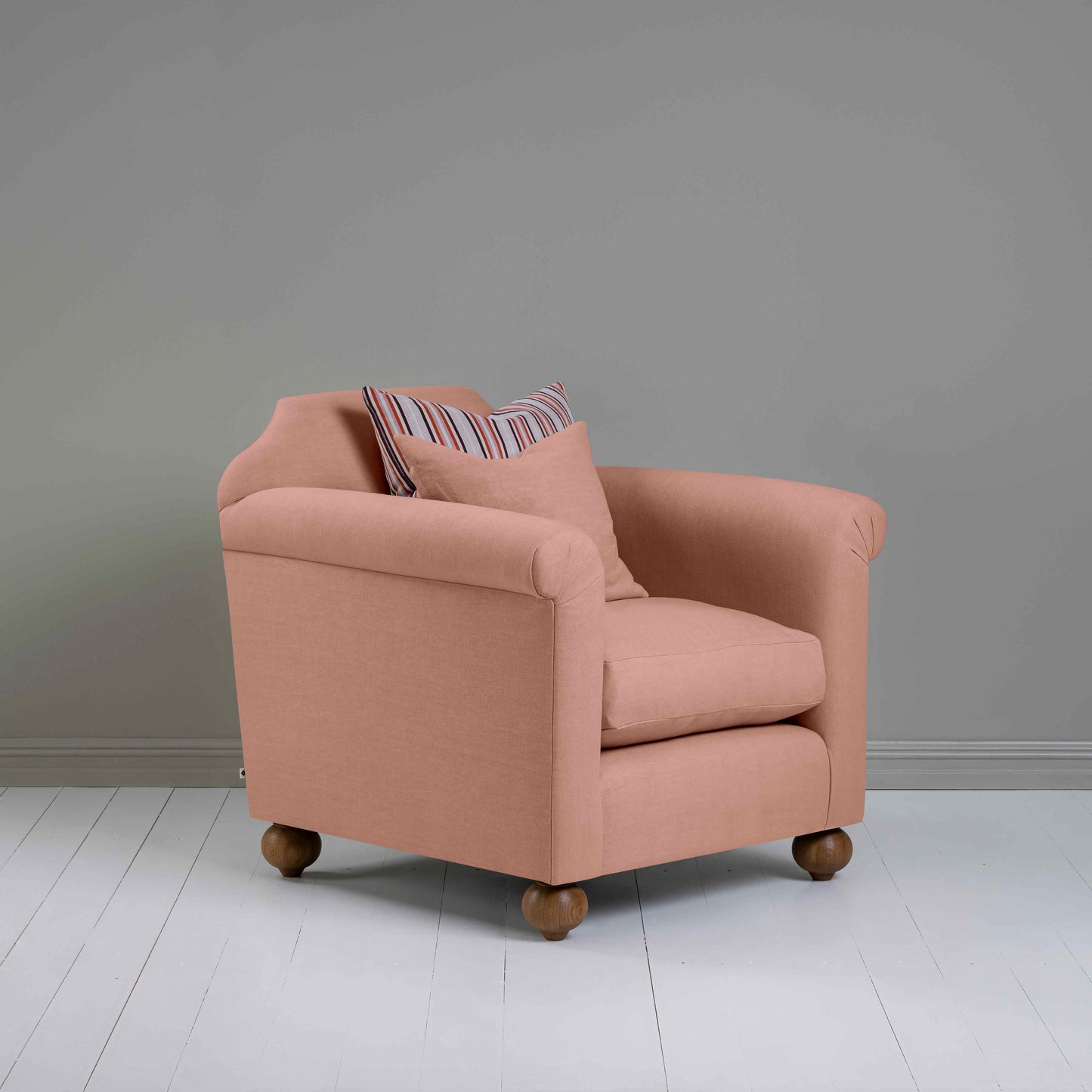 Side view of Dolittle Armchair in Laidback Linen Roseberry, featuring one matching cushion and one contrasting cushion – Nicola Harding.