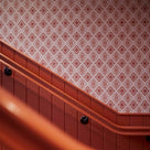 Rhombus wallpaper in Rhubarb and Pink on the wall of the stairs, adding a vibrant design element in our Beaverbrook Village Project