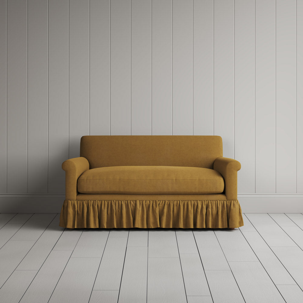 Symmetrical front view of the Ochre linen NiX sofa highlighting its gathered skirt base.
