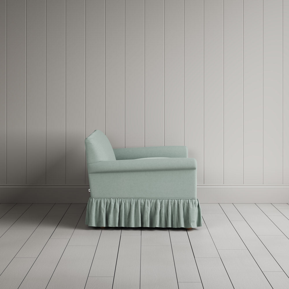 Compact side profile of a luxury sky blue linen love seat by Nicola Harding.