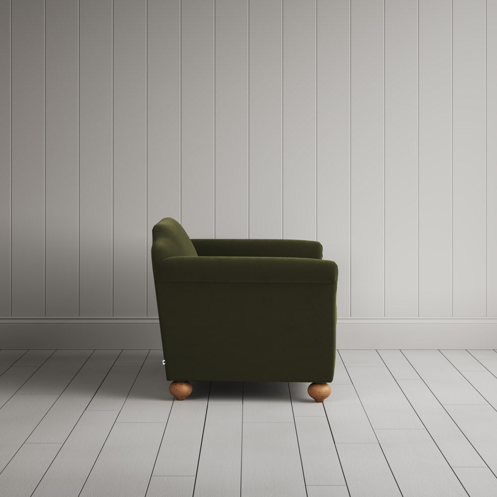 Compact side profile of a luxury green velvet love seat by Nicola Harding.