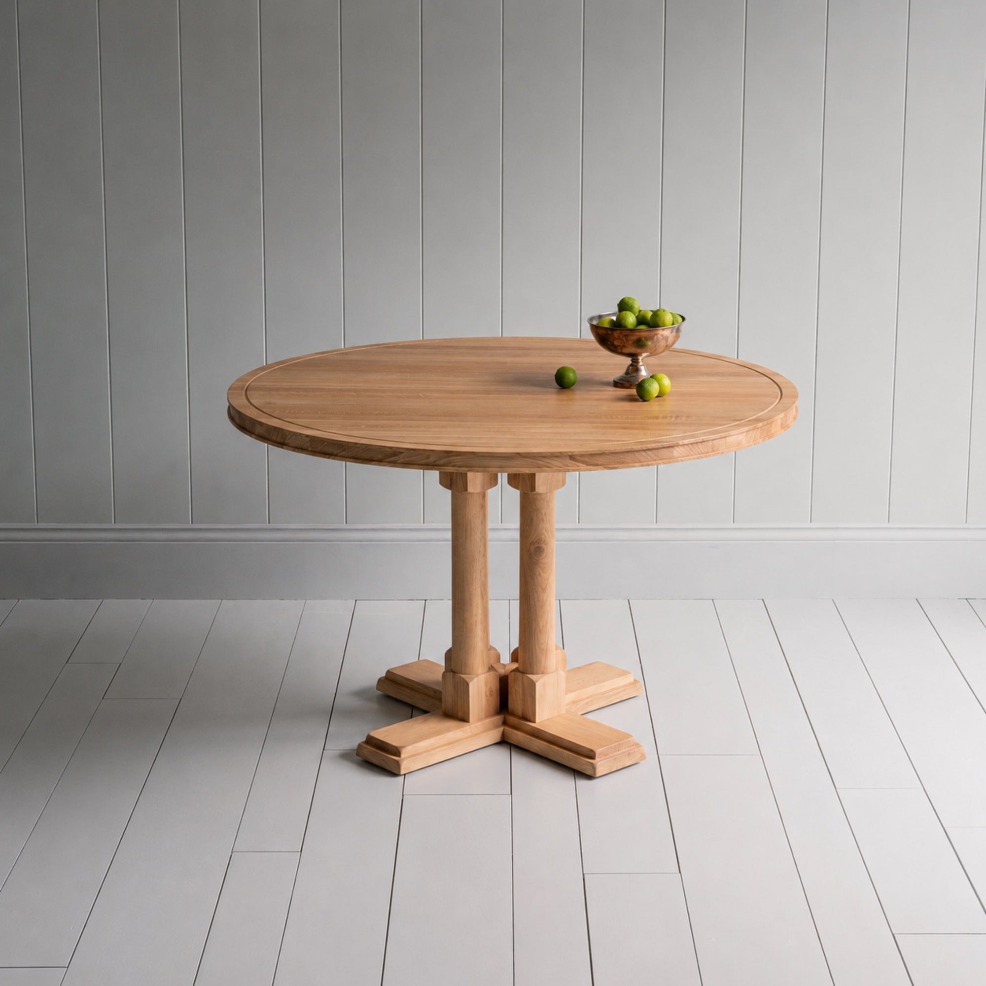 Beautiful small round dining table with a fruit basket on it, manufactured by NiX by Nicola Harding & Co.