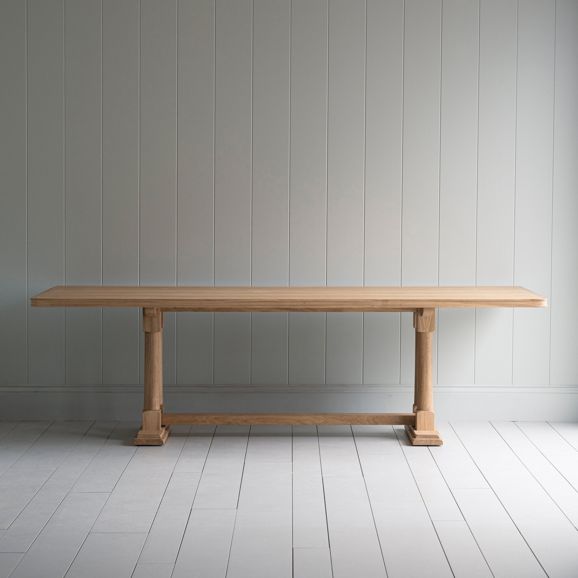 Side view of the Tuck In dining table in lacquered oak.