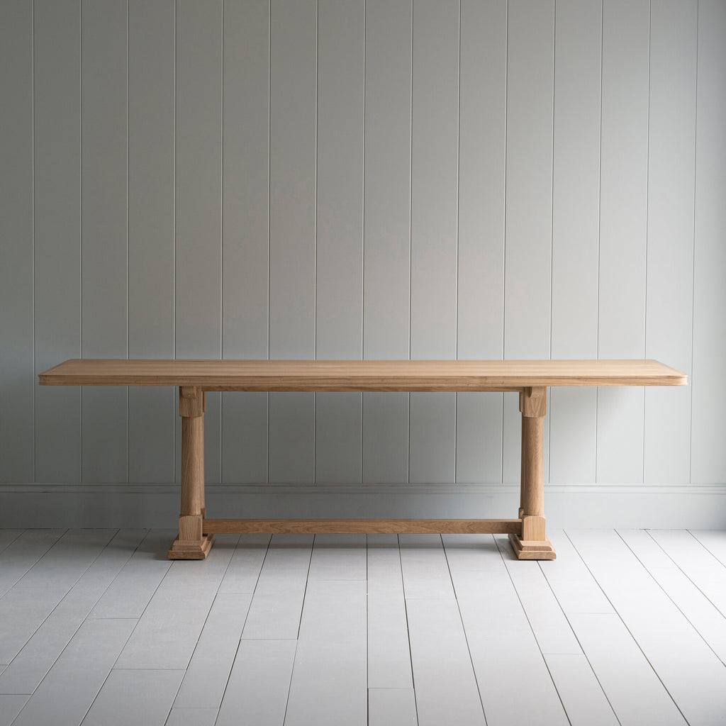 Side view of the Tuck In dining table in lacquered oak.
