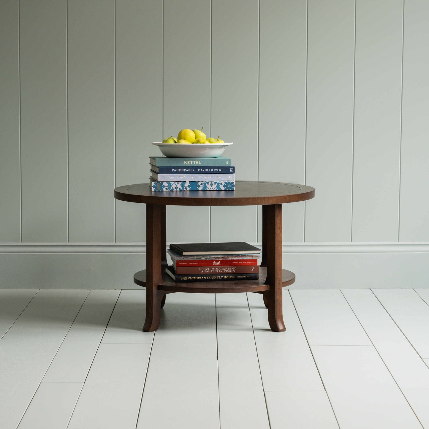 Round Perk coffee table in smoky stained oak with books and a plate of fruits, by Nicola Harding & Co.