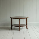 A round wooden coffee table with sturdy wooden base on the wooden floor - By NiX