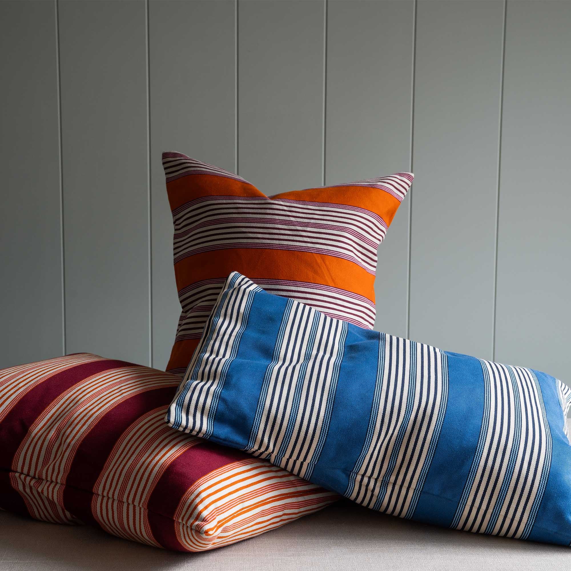 NiX Limited Edition Rectangle Coddle Cushion in Flow Cotton Linen, Marmalade Orange, Cool Blue and Rowan Red.
