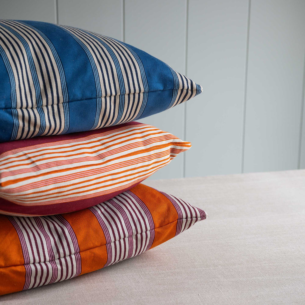 Three Beautiful Rectangle Coddle Cushion in Flow Cotton Linen, Marmalade Orange and Blue - Limited Edition on top of each other.