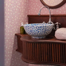 Beautiful round basin in a washroom with Ginkgo wallpaper in Rose Pink, designed by (NiX by Nicola Harding & Co.)