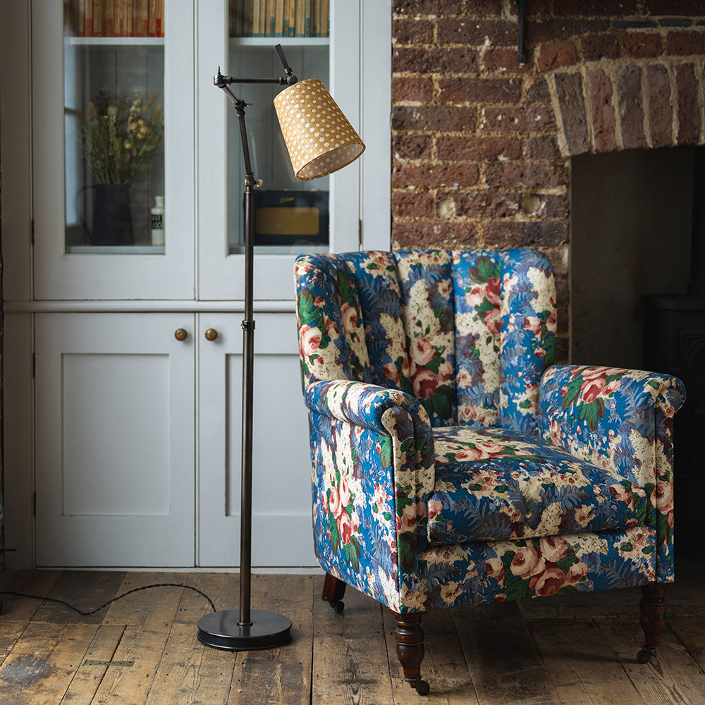 Focused Floor Lamp in Waxed Brass, With To The Point Batik Paper Empire Lamp Shade in Spotty Dotty Tan, Next to a Beautifull High Back Armchair - Nicola Harding