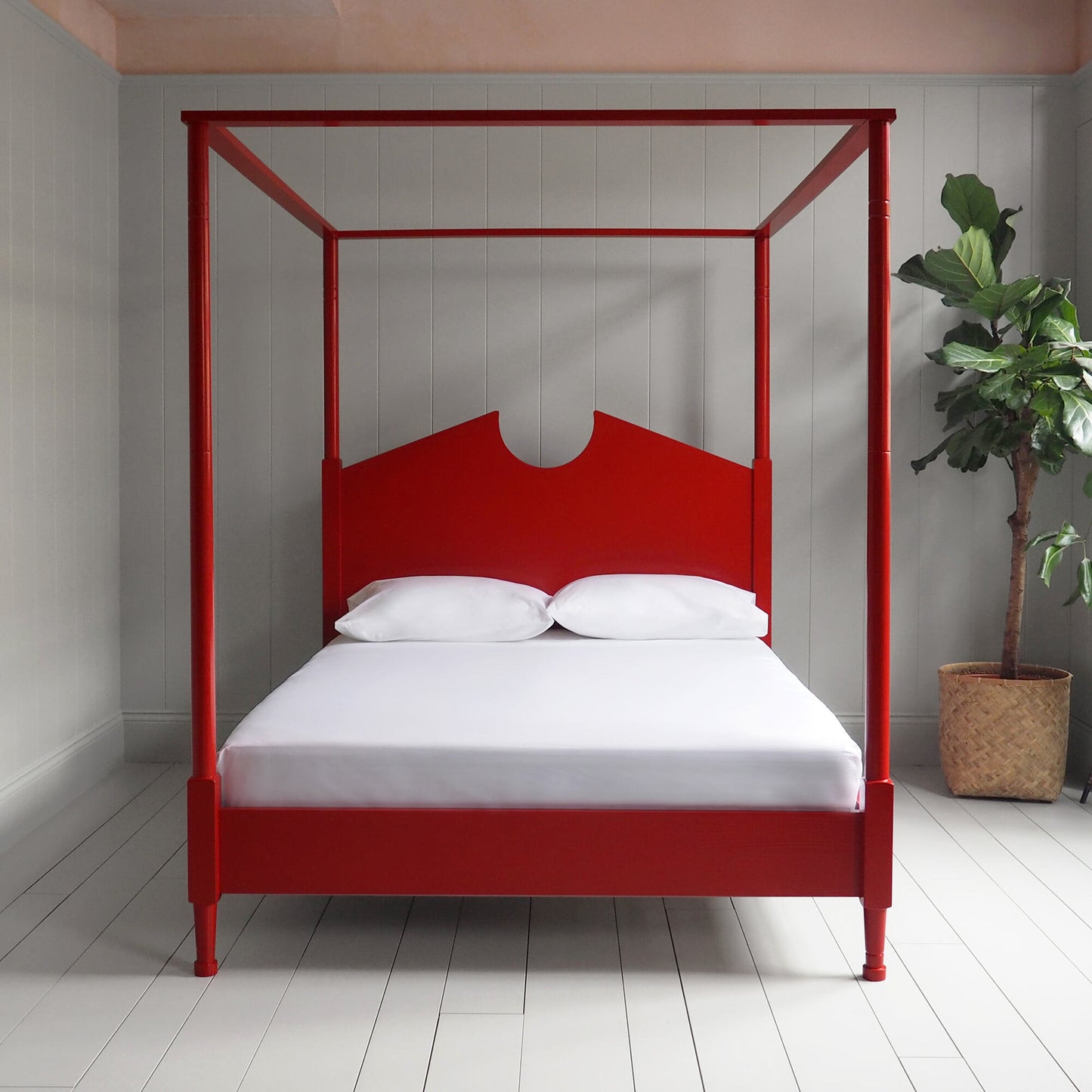 A red canopy bed with crisp white sheets, creating a serene and elegant atmosphere.
