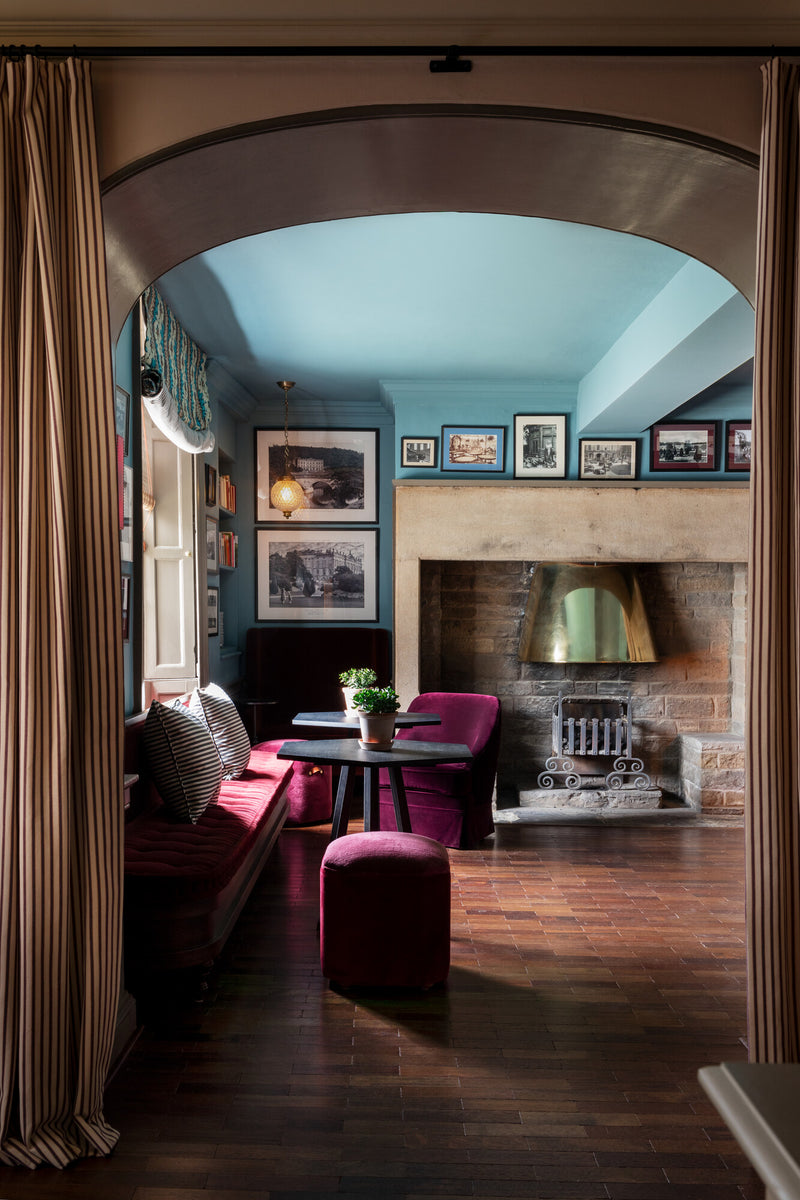 The Hotel Cavendish Baslow hallway has a cozy fireplace and was designed by Nicola Harding & Co.