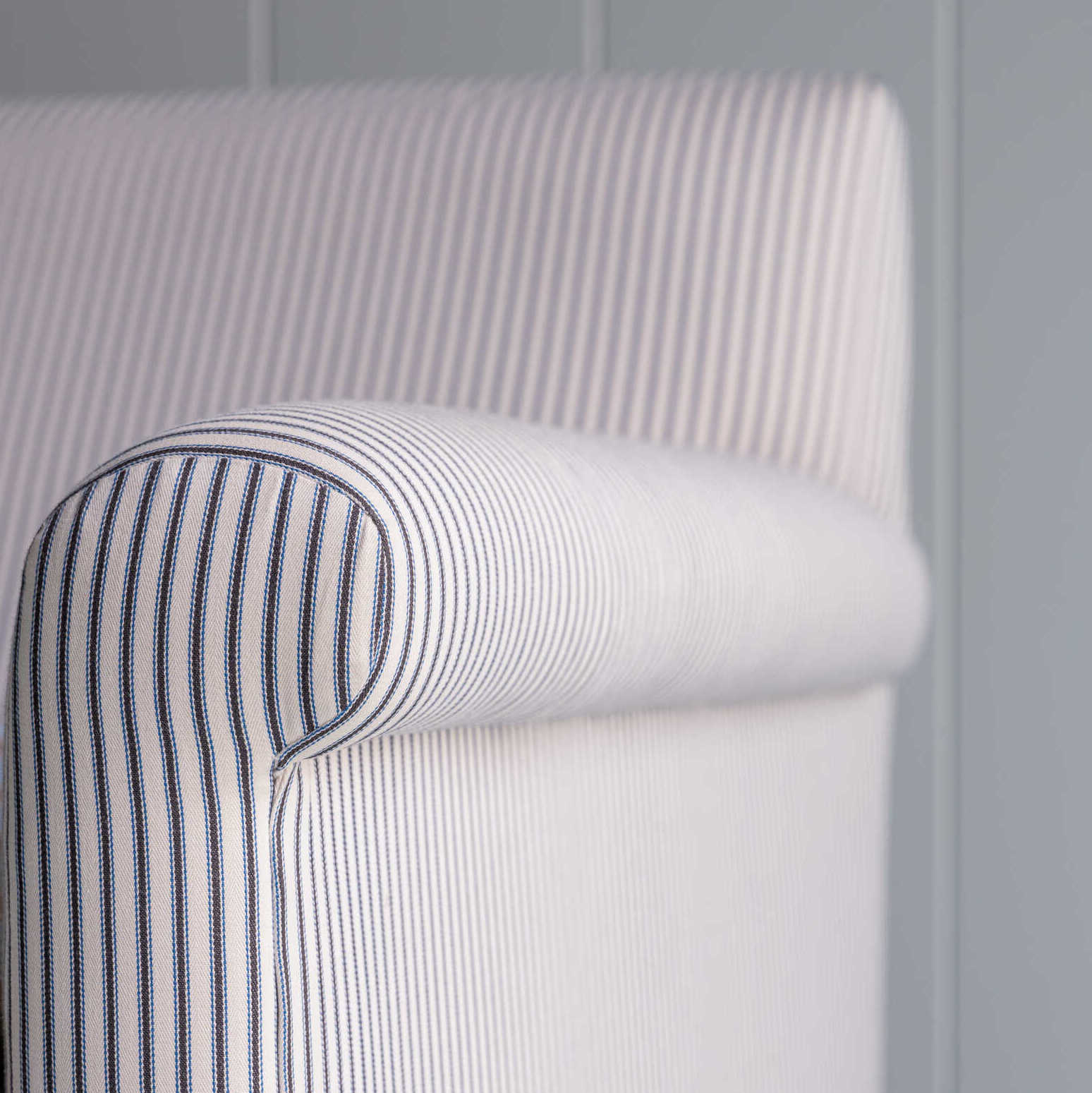 Close-up of the arm design of the Idler 2-seater sofa in Ticking Cotton Chocolate Navy fabric by NiX.