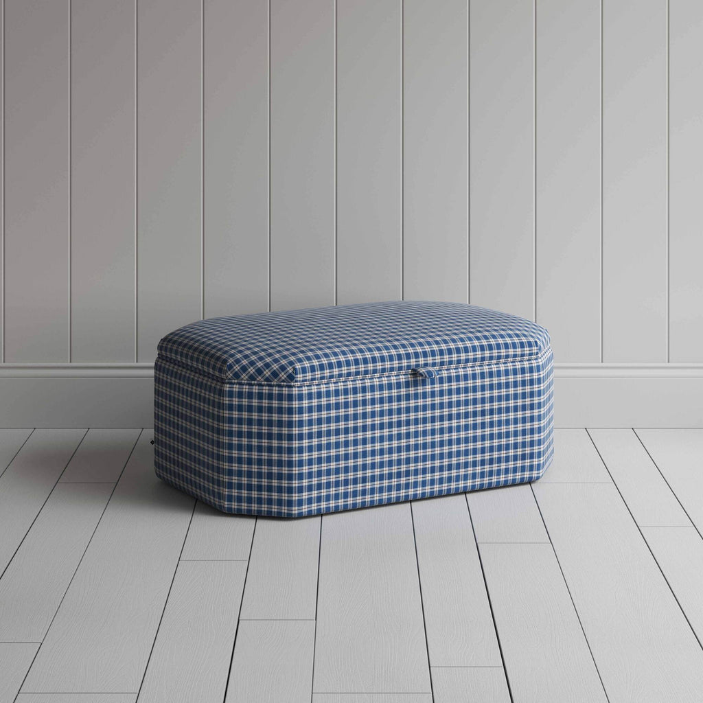 Blue and white checkered ottoman on wooden floor.