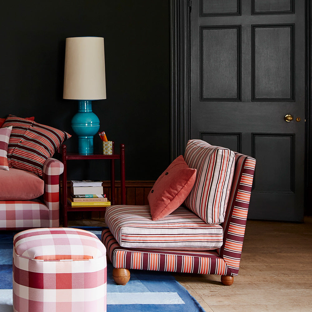 Slipper Armchair In Regatta Cotton Flame Frame and Slow Lane Cotton Linen Berry Seat, With Cushion, an Ottoman With a Red Side Table With a Blue Base Lamp - By NiX