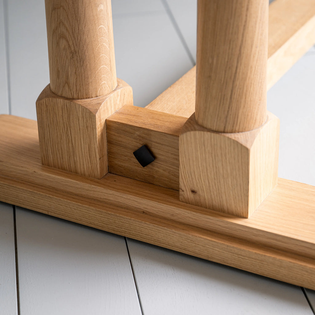 Close-up of the foot design on the Tuck In rectangular dining table in oak wood, by NiX.