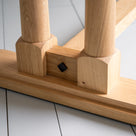 Close-up of the foot design on the Tuck In rectangular dining table in oak wood, by NiX.