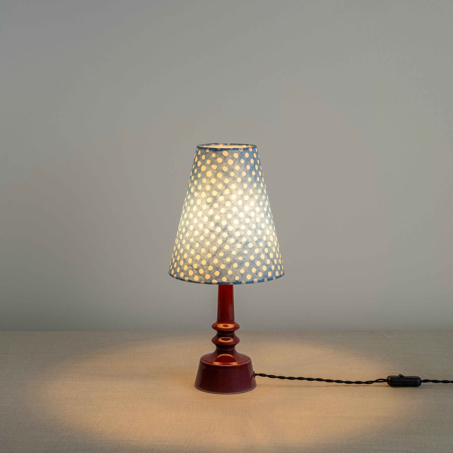 Ditsy Ceramic Table Lamp Base in Damson Pink, With Ditsy Tall Tapered Lamp Shade in Dotty Sky Blue, With Lights ON - Nicola Harding