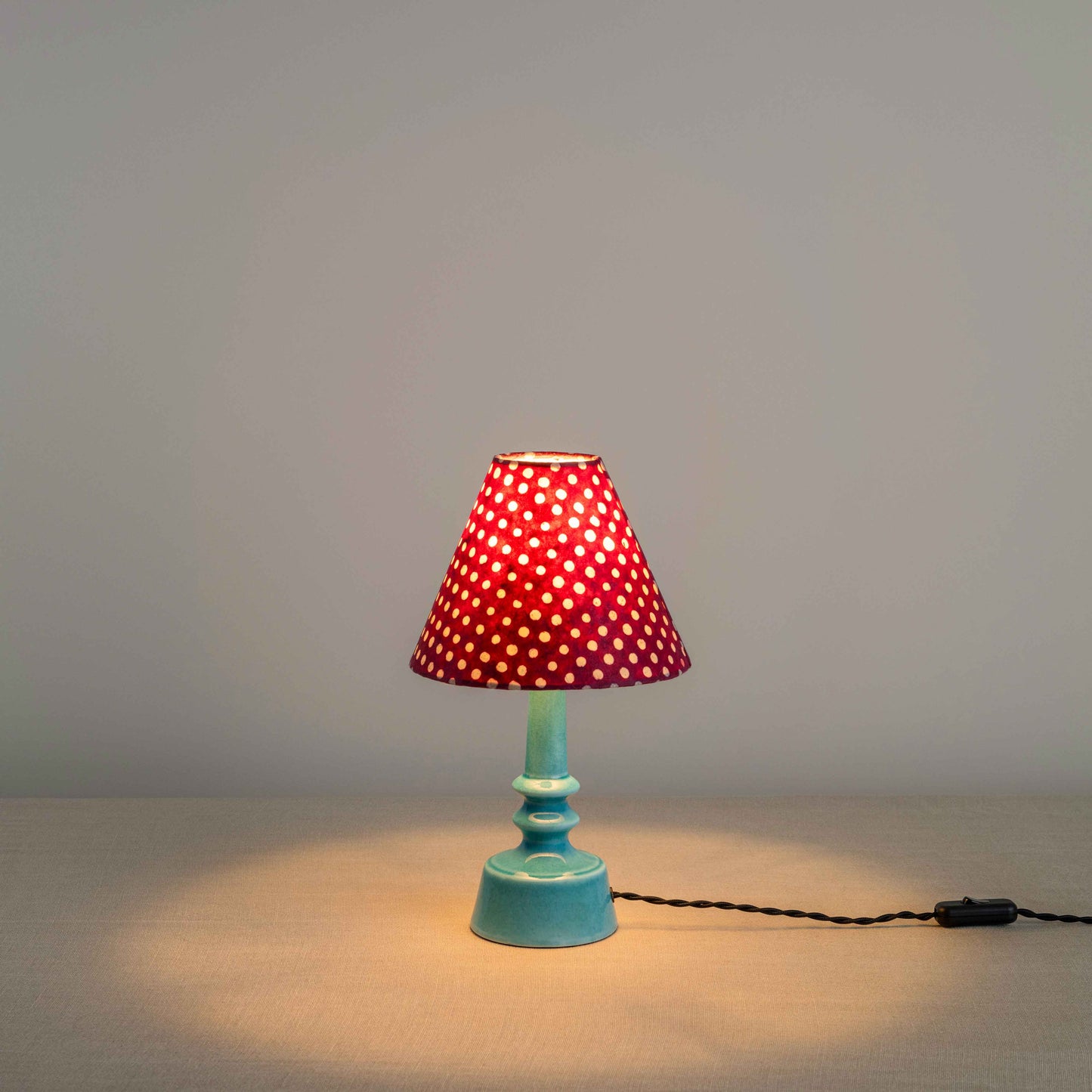 Ditsy Ceramic Table Lamp Base in Turquoise, With Ditsy Classic Empire Lamp Shade in Dotty Maroon, With Lights 'ON' - Nicola Harding