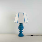 Hourglass Ceramic Table Lamp Base in Blue, With Townhouse Hexagonal Lamp Shade in Soft White with Peacock Blue Trim & Stitching - Nicola Harding