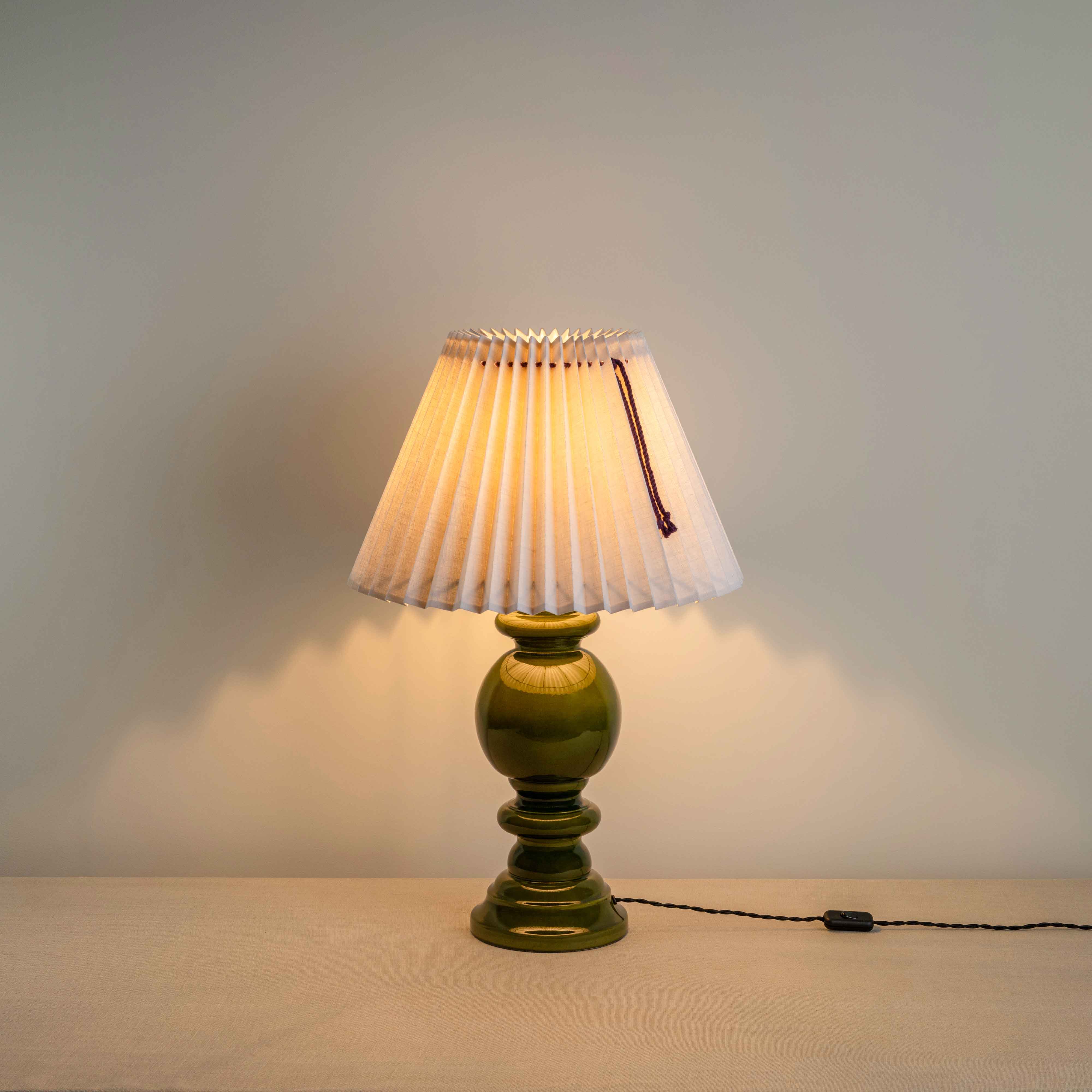 Hourglass Ceramic Table Lamp Base in Green, With Sunburst Concertina Natural Pleat Lamp Shade with Blackberry Cord With Lights 'ON' - Nicola Harding