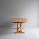 Side View of Tuck-In Oval Dining Table in Lacquered Oak - Nicola Harding & Co.