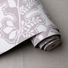 Albion Wallpaper in Mauve, shown as a roll, designed by Nicola Harding & Co.