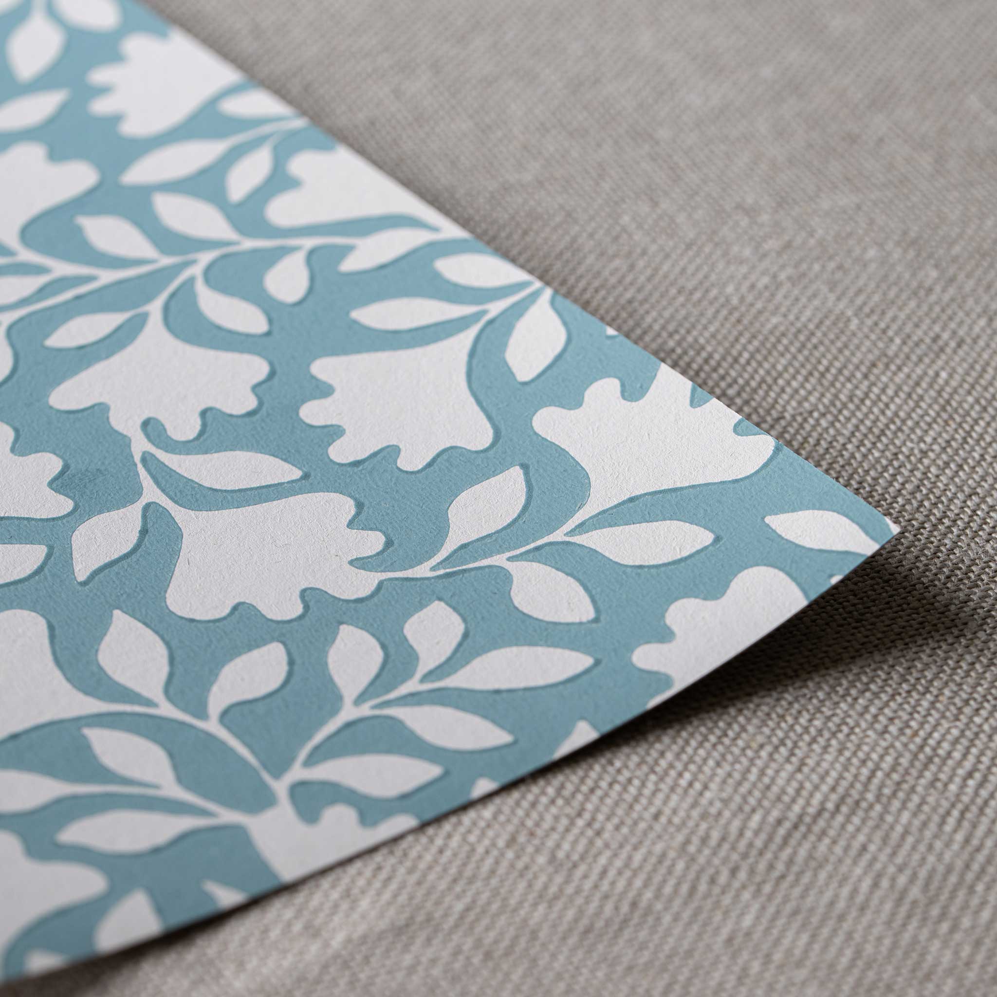 Closeup of edge design finishing with blue wallpaper in peacock pattern, designed by Nicola Harding