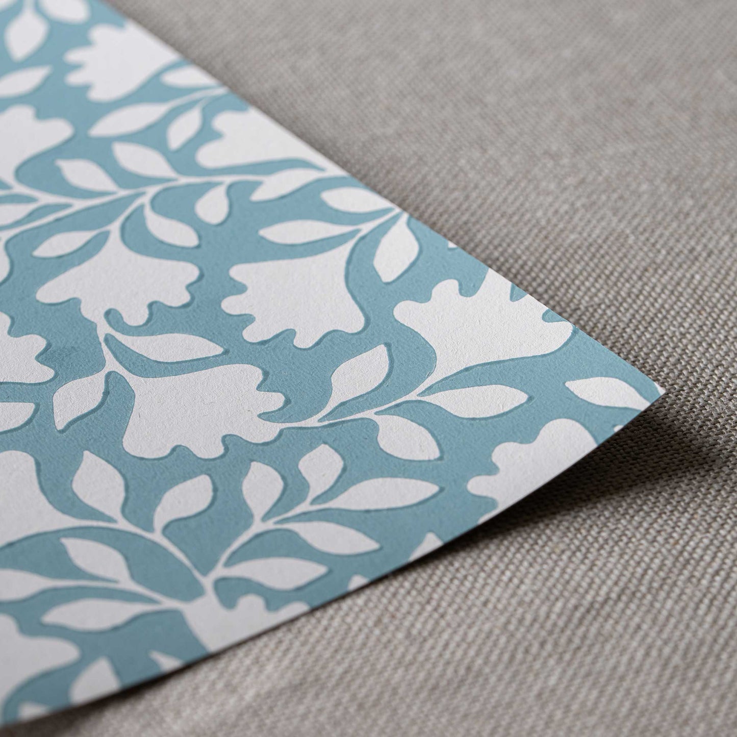 Closeup of edge design finishing with blue wallpaper in peacock pattern, designed by Nicola Harding