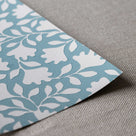 Closeup of edge design finishing with blue wallpaper in peacock pattern, designed by Nicola Harding