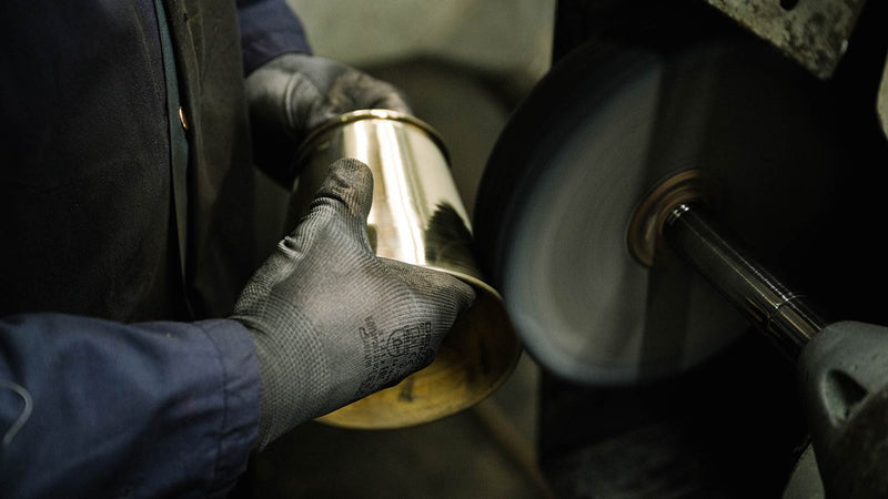 Skilled artisan polishing a brass lamp shade from our Focused collection, ensuring a flawless finish and exquisite craftsmanship