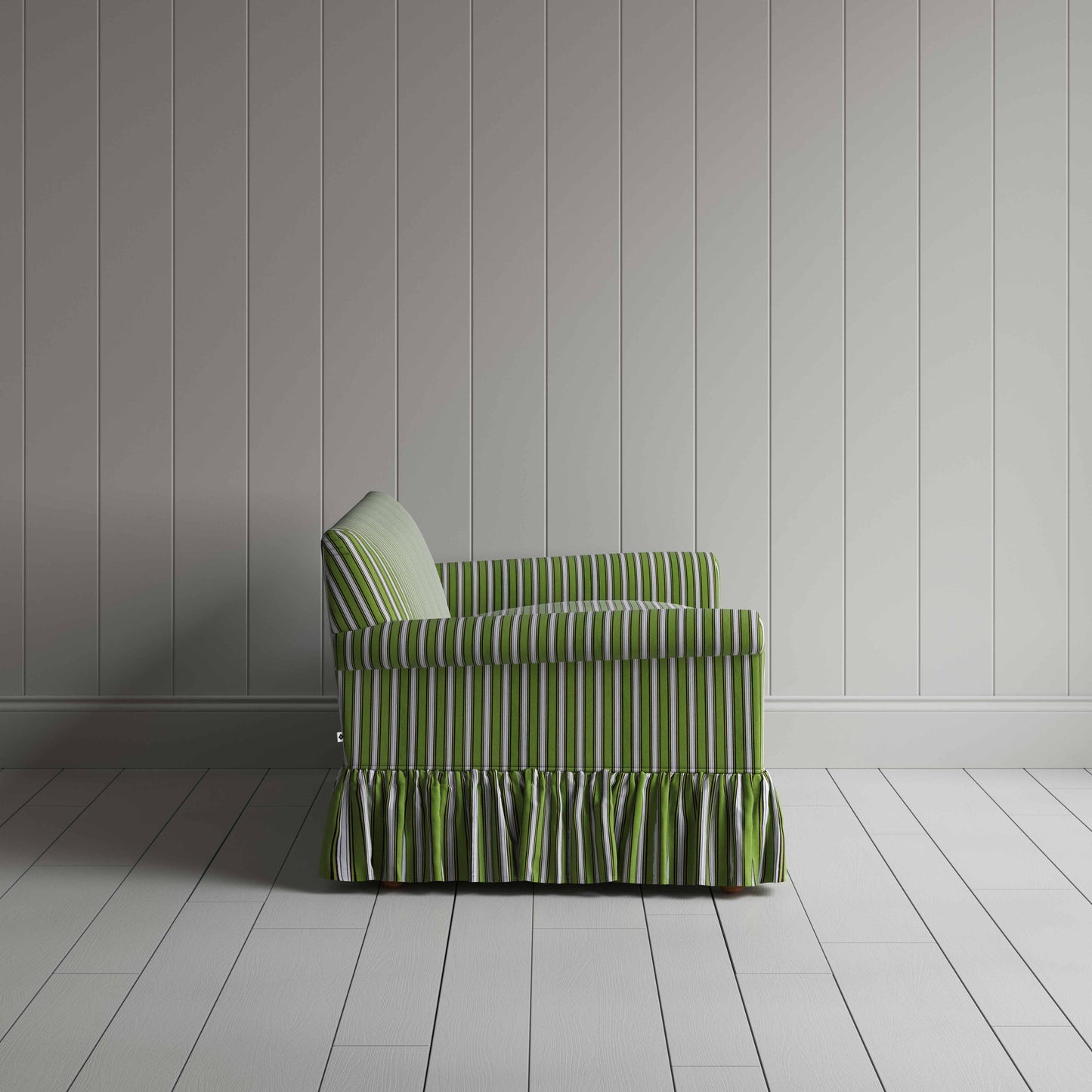 Green ruffled skirt sofa in front of wall