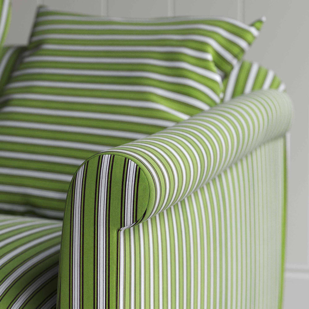  A green and white striped couch in close-up view. 