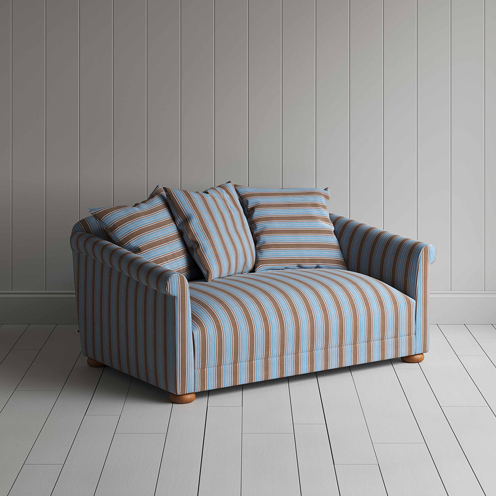  Blue and white striped sofa on wooden floor. 