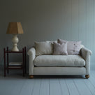  NiX 2-seater sofa with 2 rectangular cushions, 1 square NiX cushion, a red side table, and a white base lamp. - NiX 