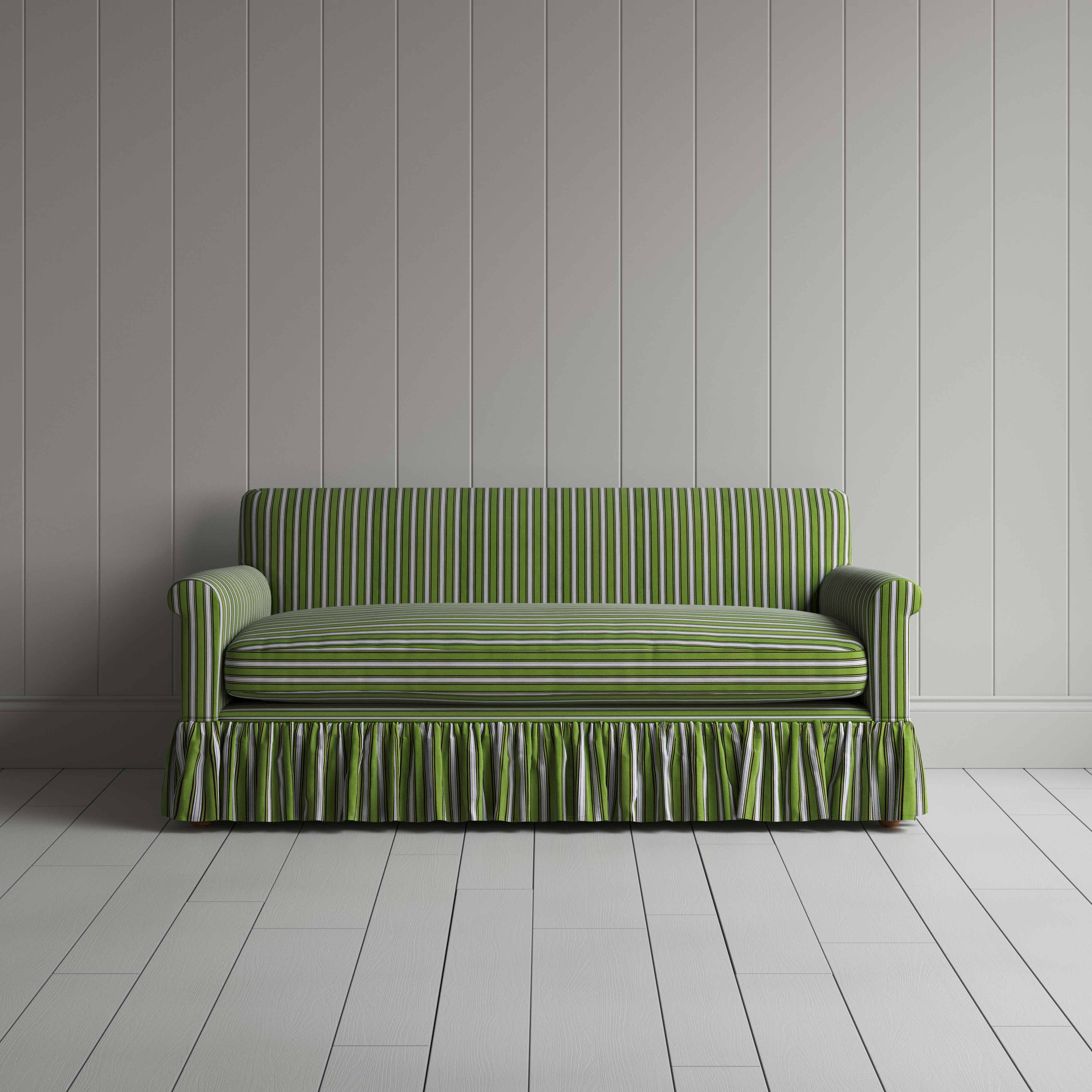  A green sofa with a ruffled skirt placed in front of a wall. 