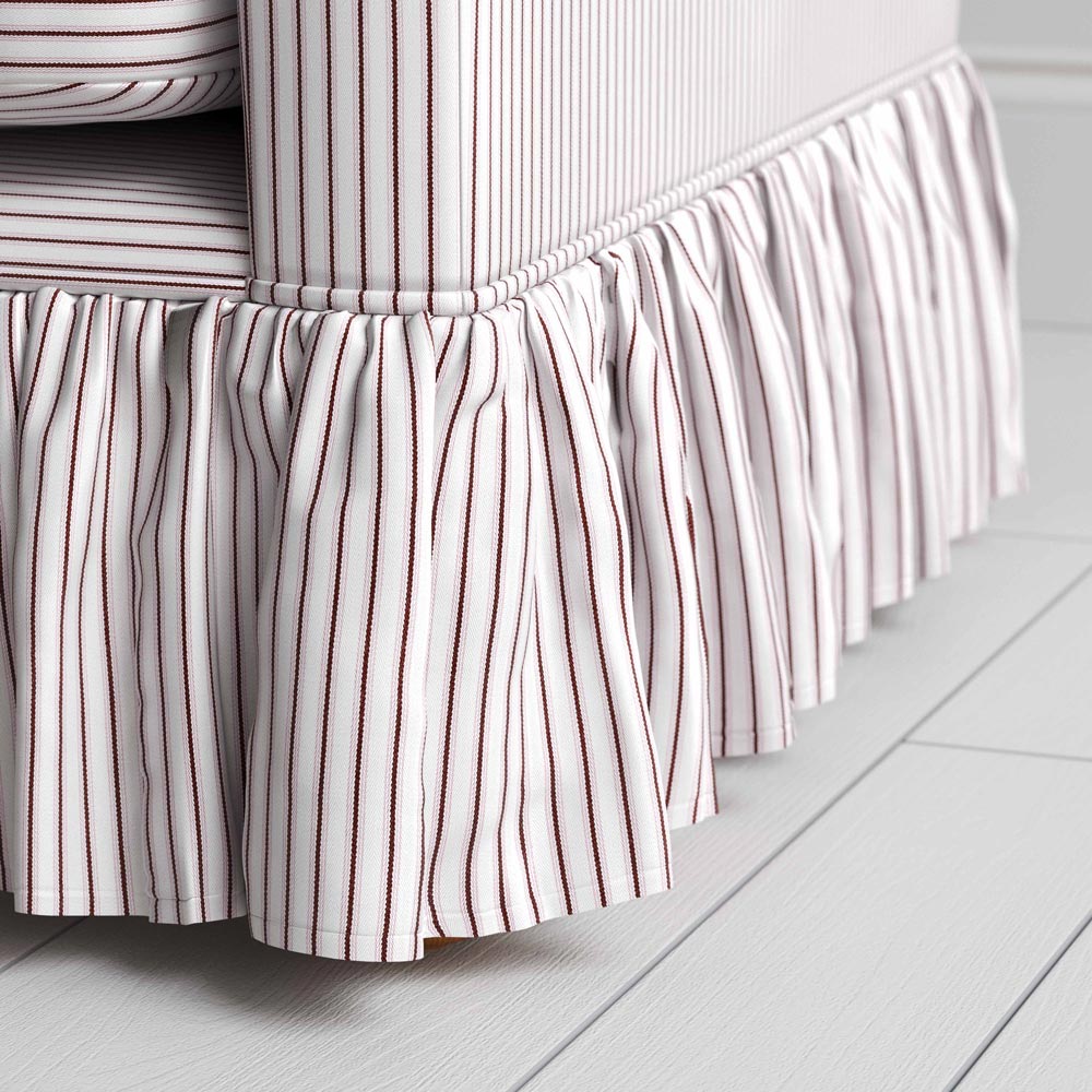 A close-up of a brown and white striped sofa skirt, adding a touch of elegance to the bedroom decor.