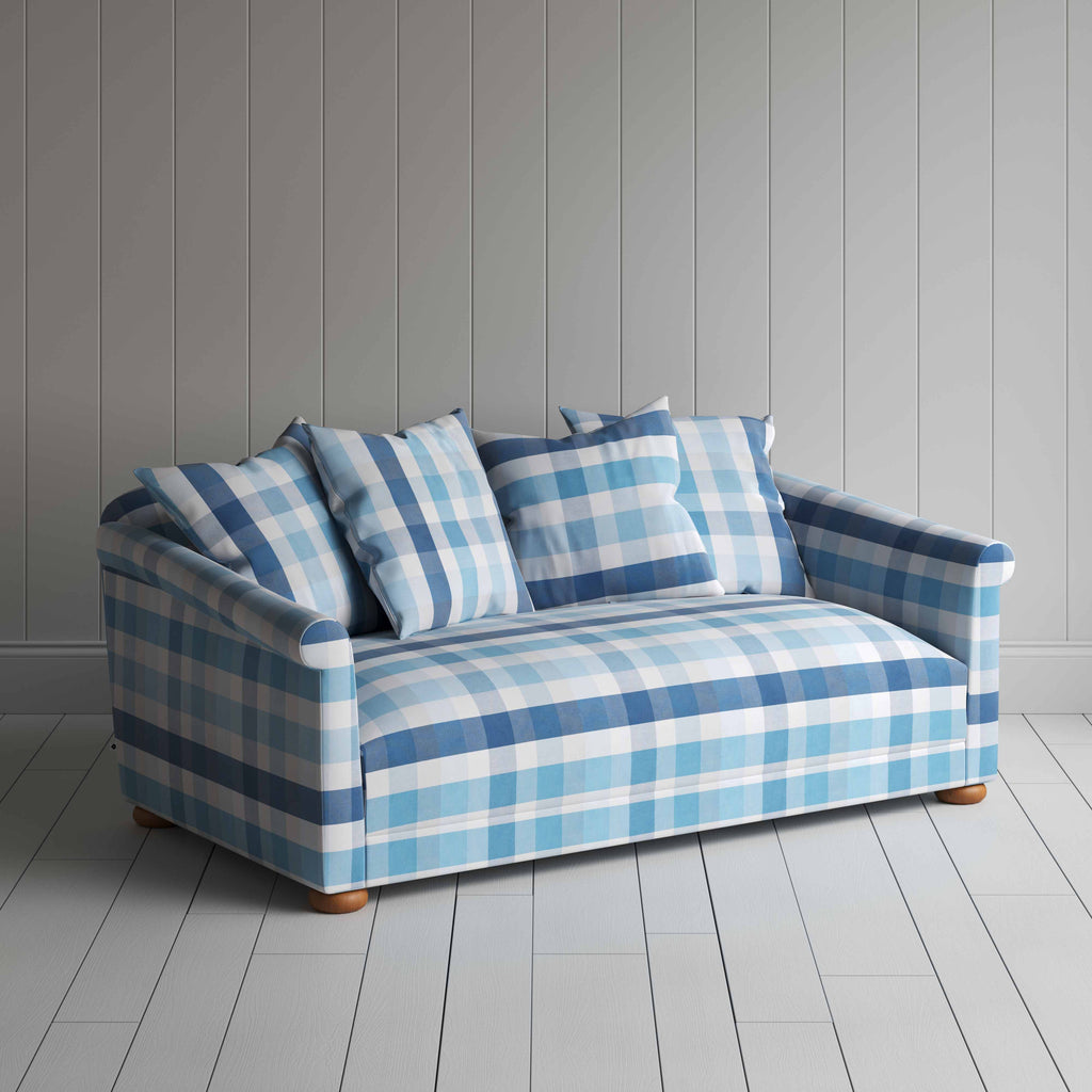  A cozy blue and white checkered sofa adorned with pillows, creating a stylish and inviting seating area. 