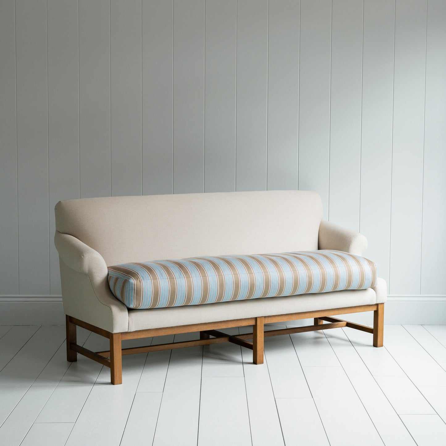 White couch on wooden floor in minimalist living room.