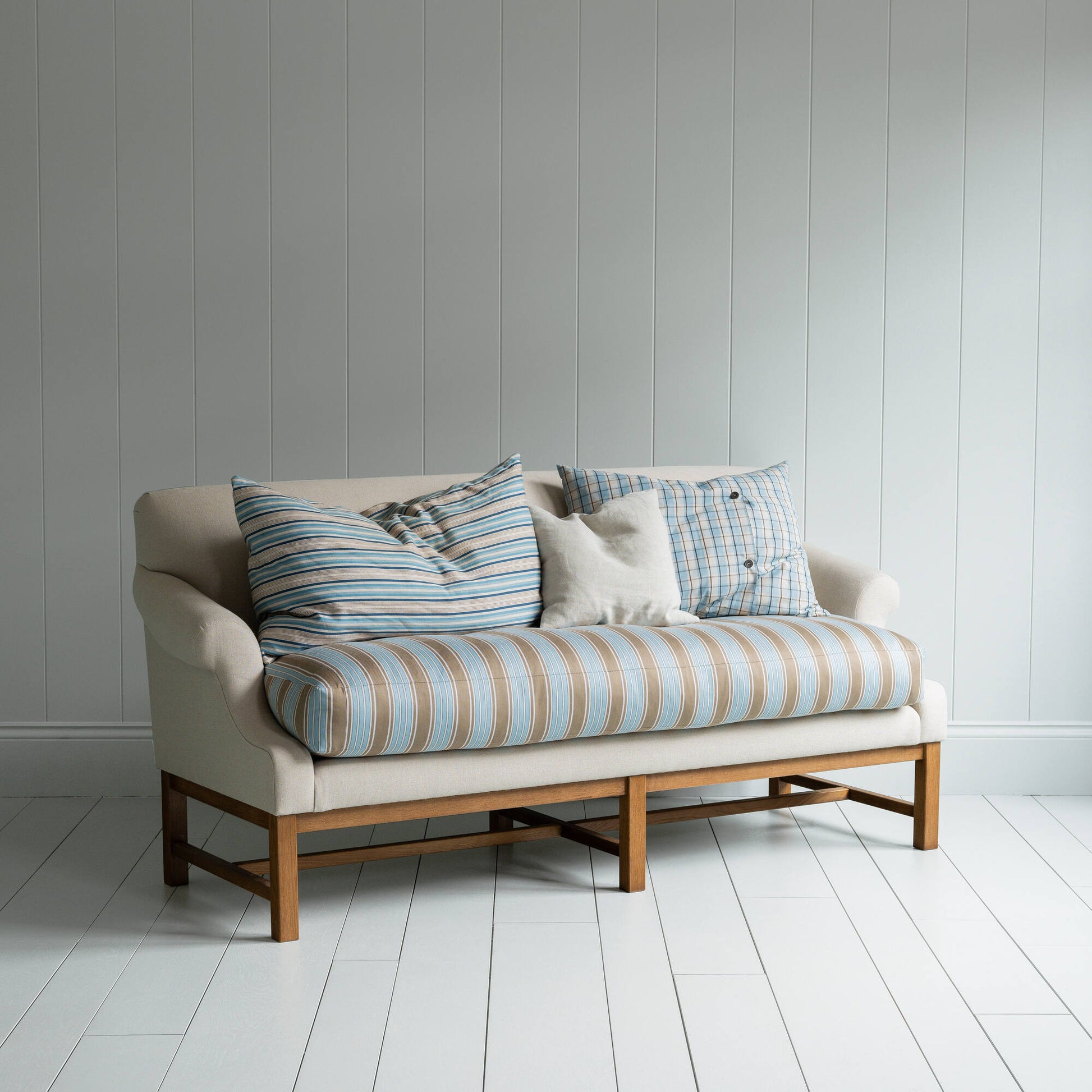 White couch on wooden floor in minimalist living room.