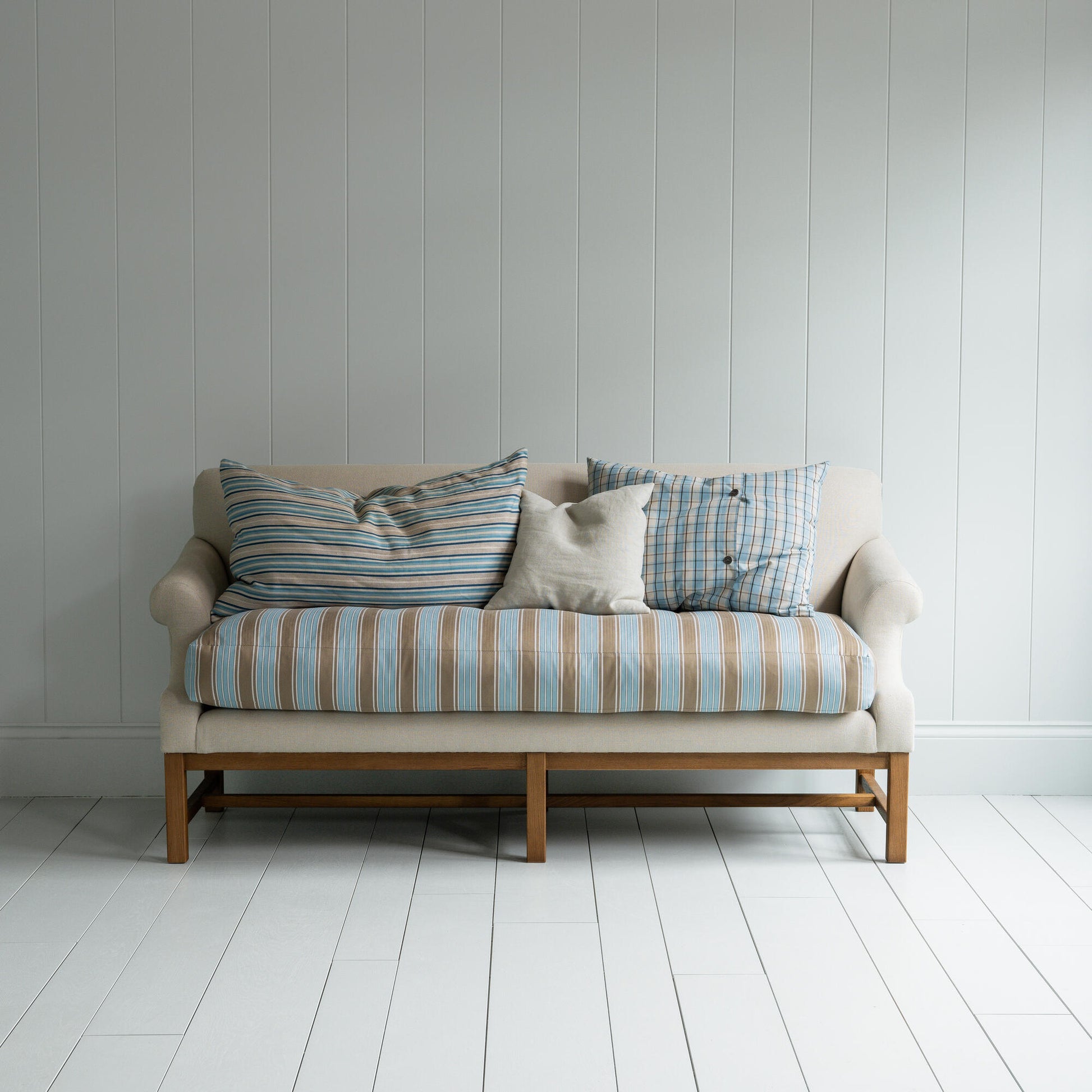 White couch on wooden floor in minimalist living room.