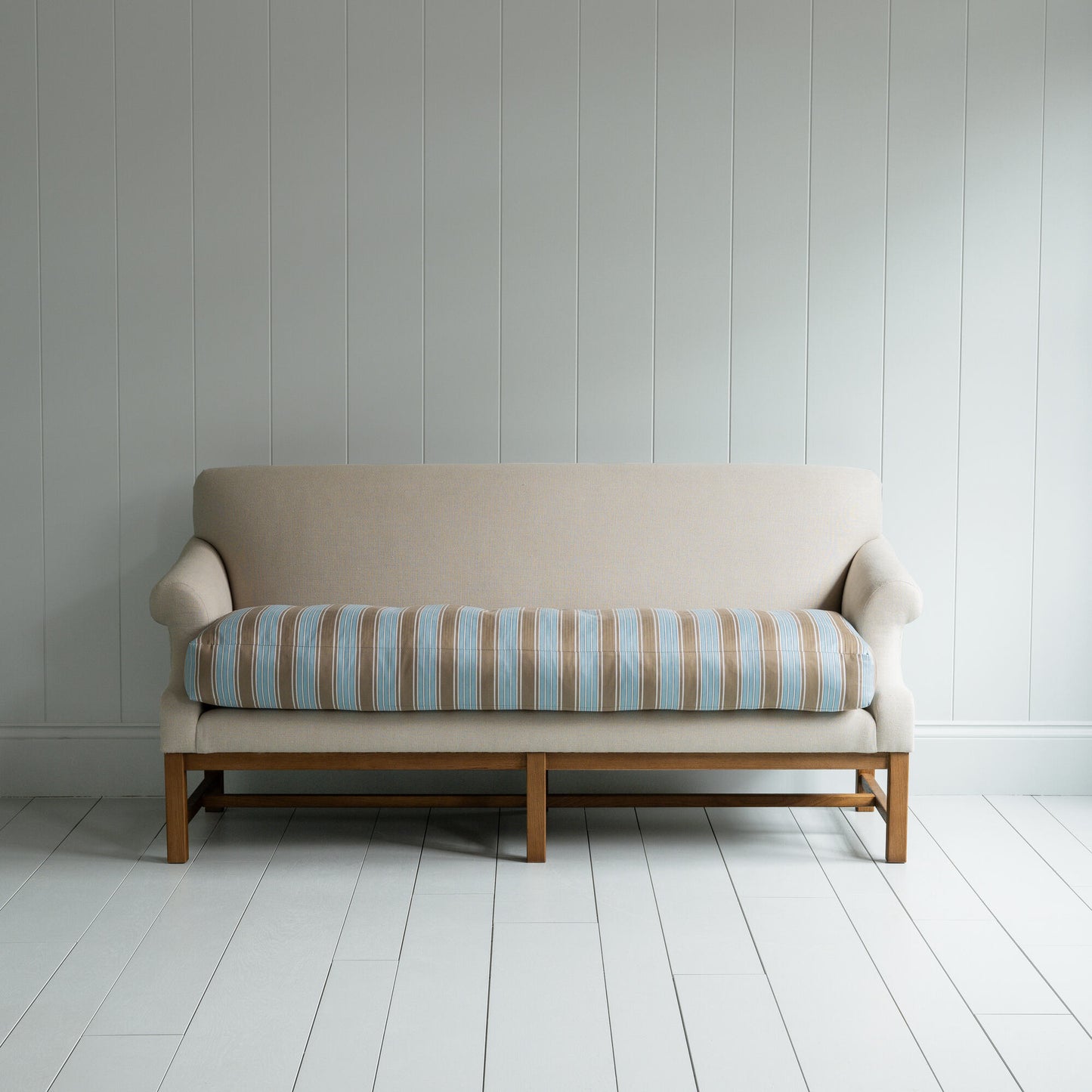 White couch on wooden floor in minimalist living room.