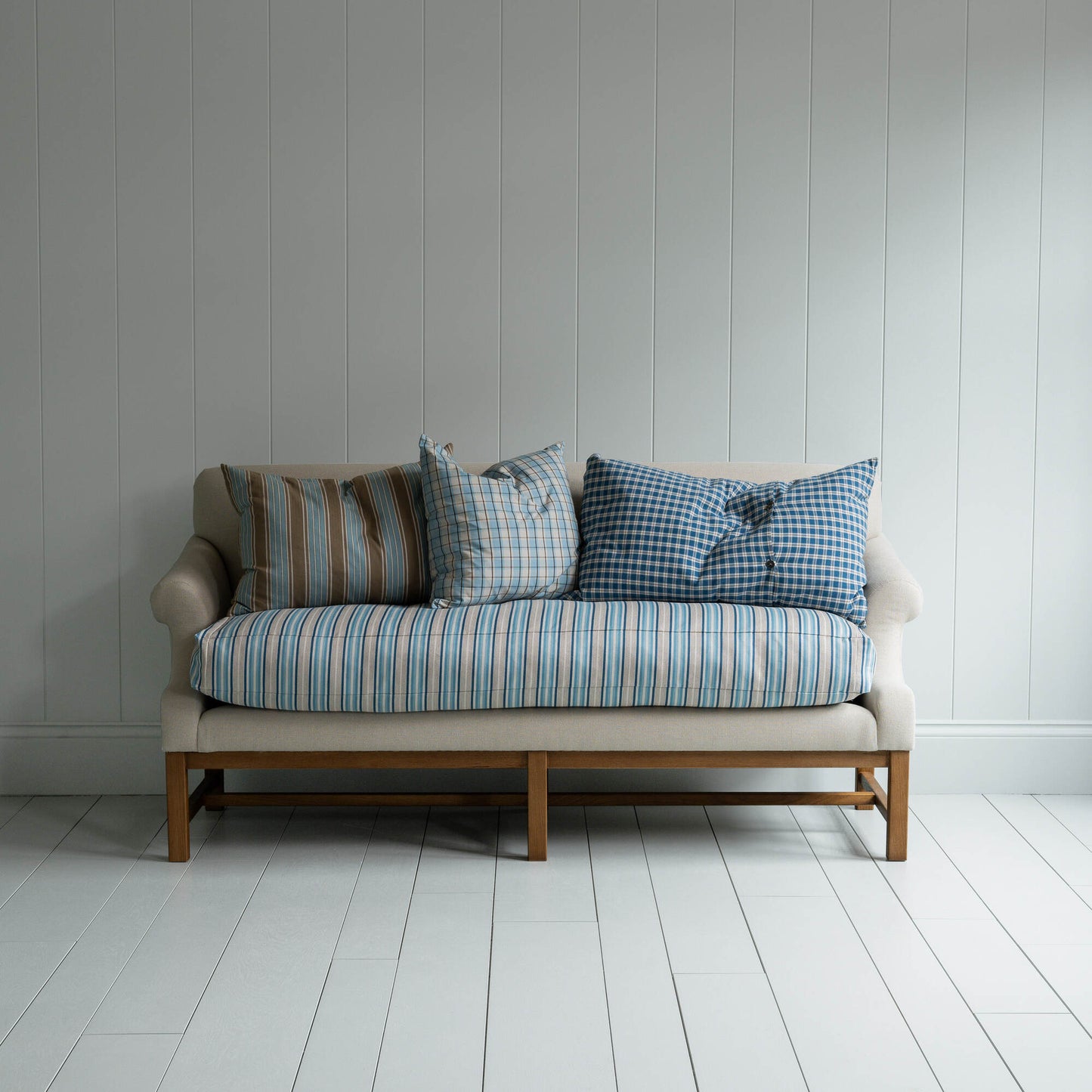 White couch on wooden floor in minimalist living room.