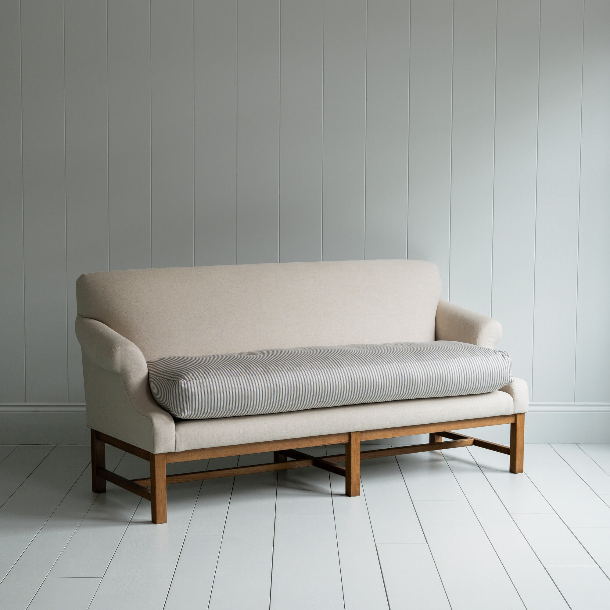 White couch on wooden floor in minimalist living room. 
