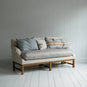  White couch on wooden floor in minimalist living room. 