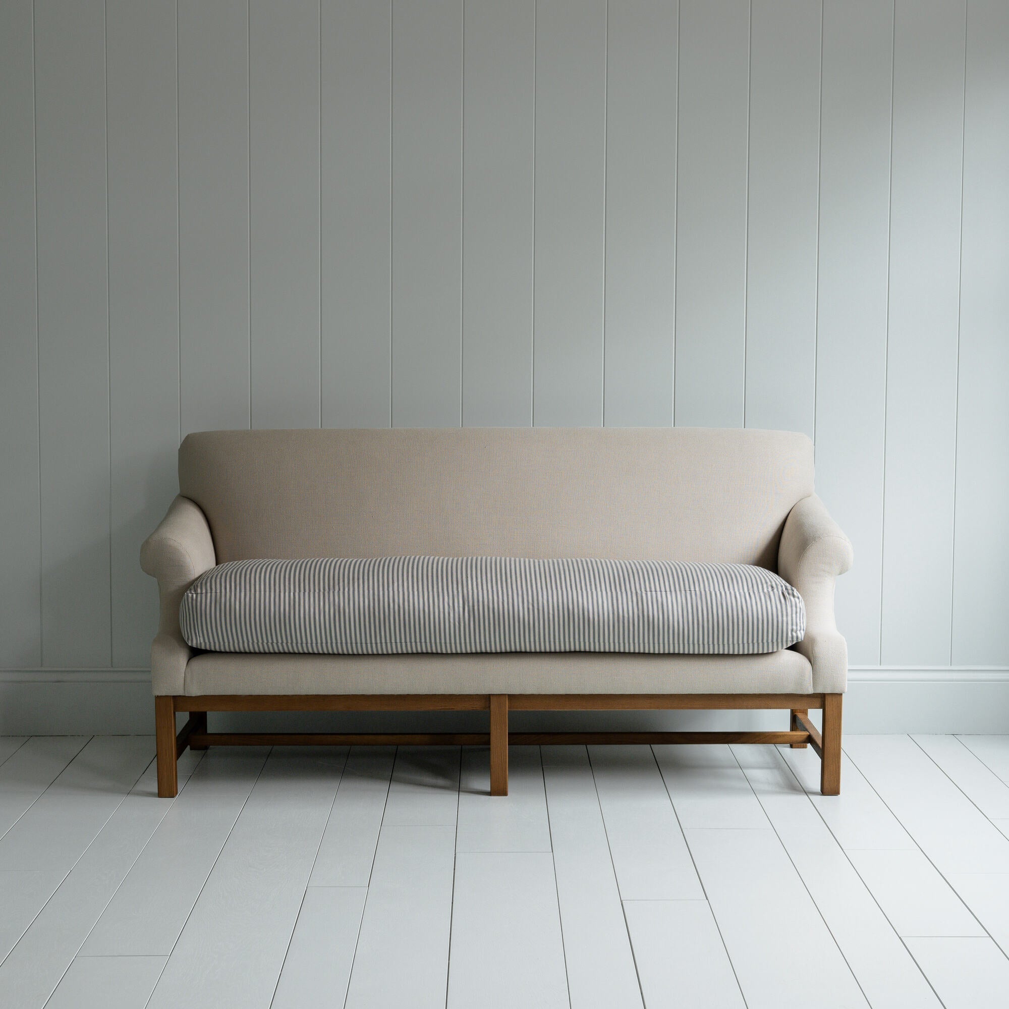  White couch on wooden floor in minimalist living room. 