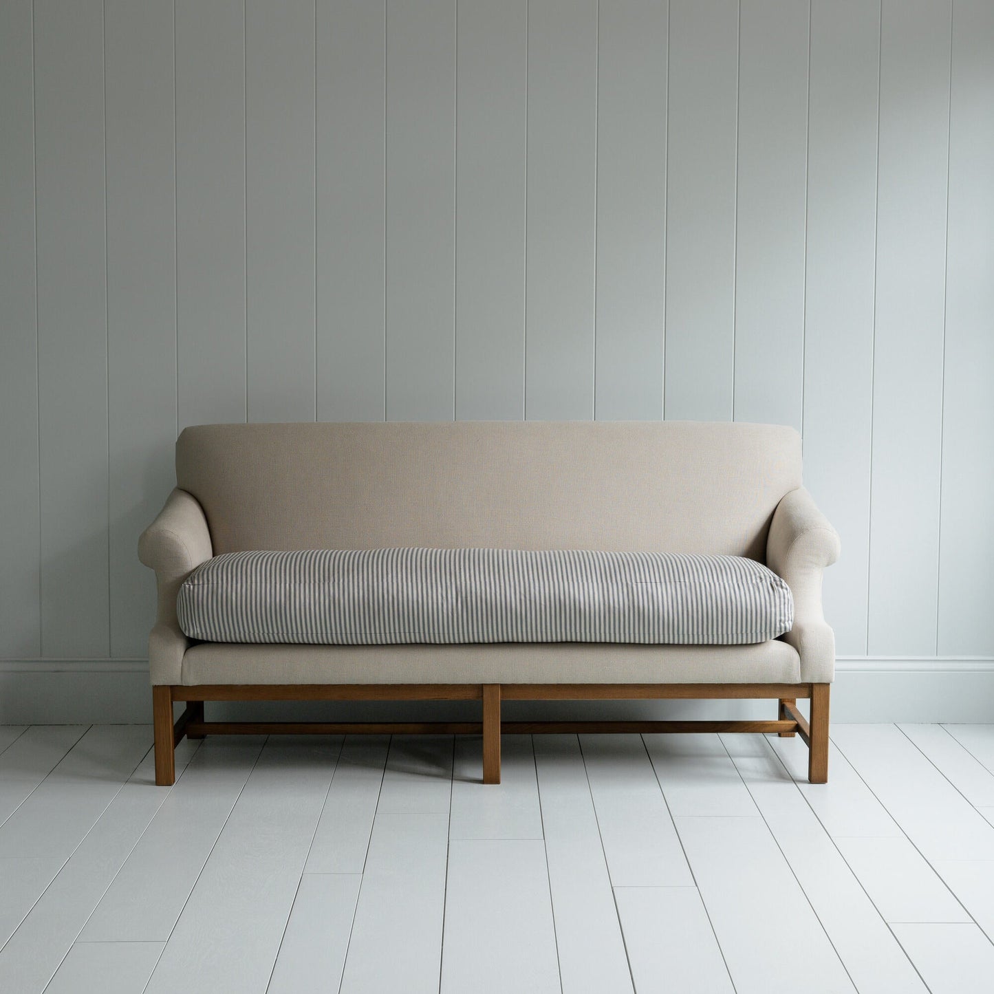 White couch on wooden floor in minimalist living room.