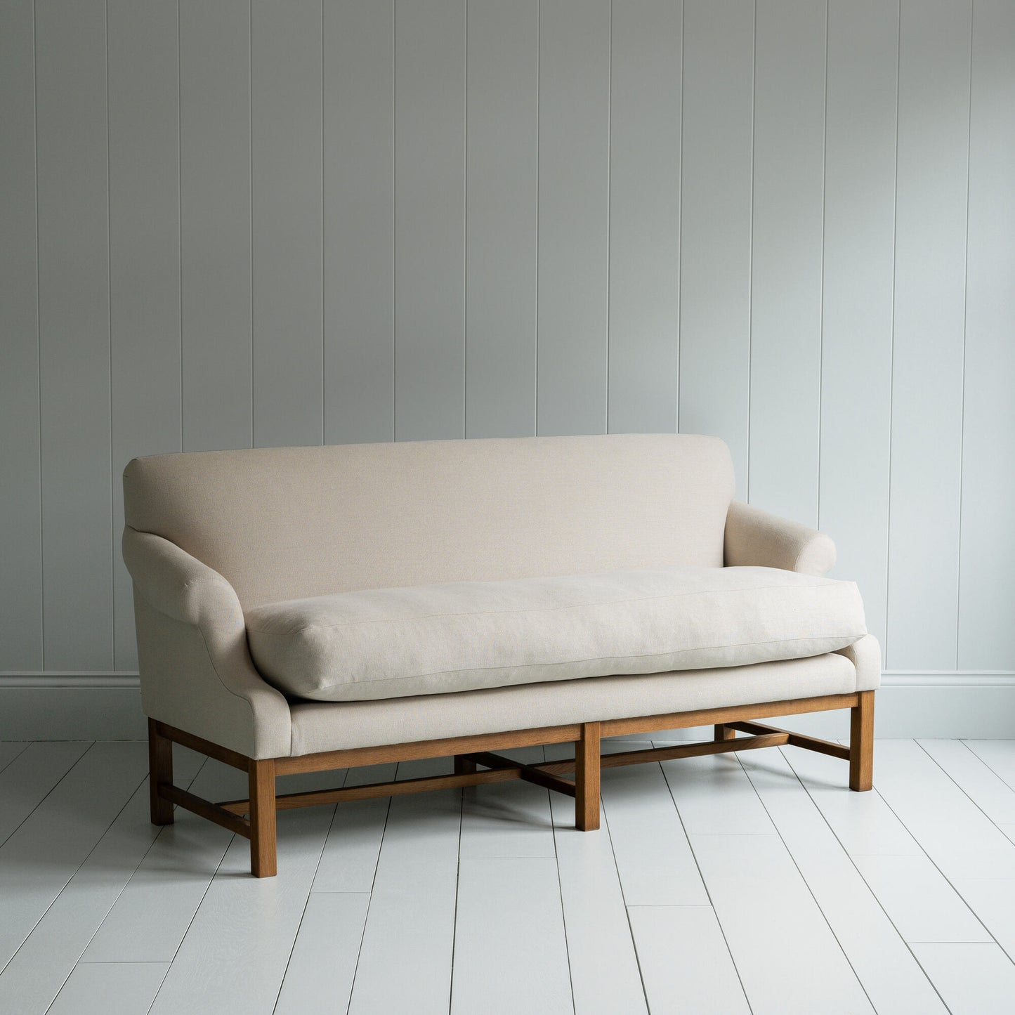 White couch on wooden floor in minimalist living room.