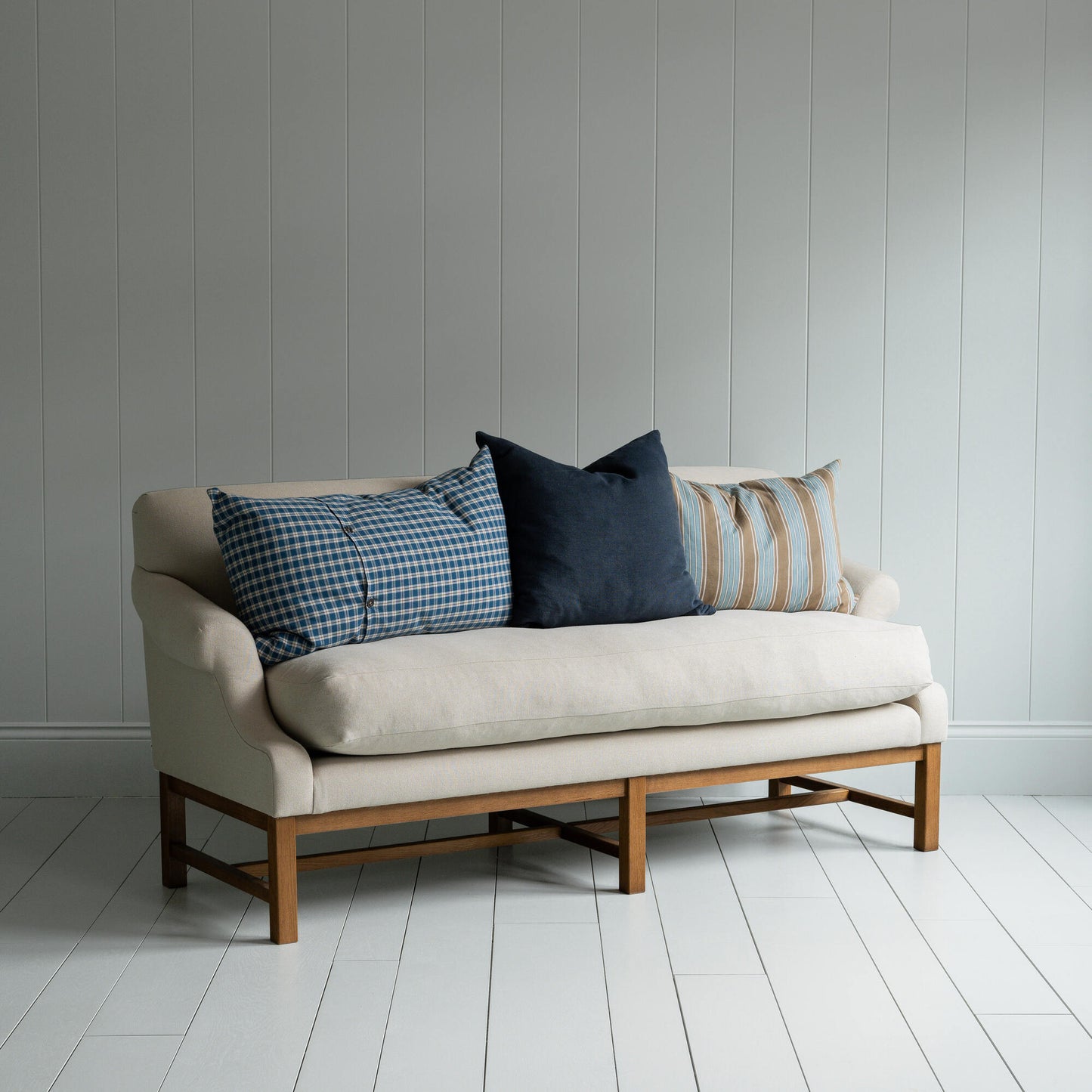 White couch on wooden floor in minimalist living room.